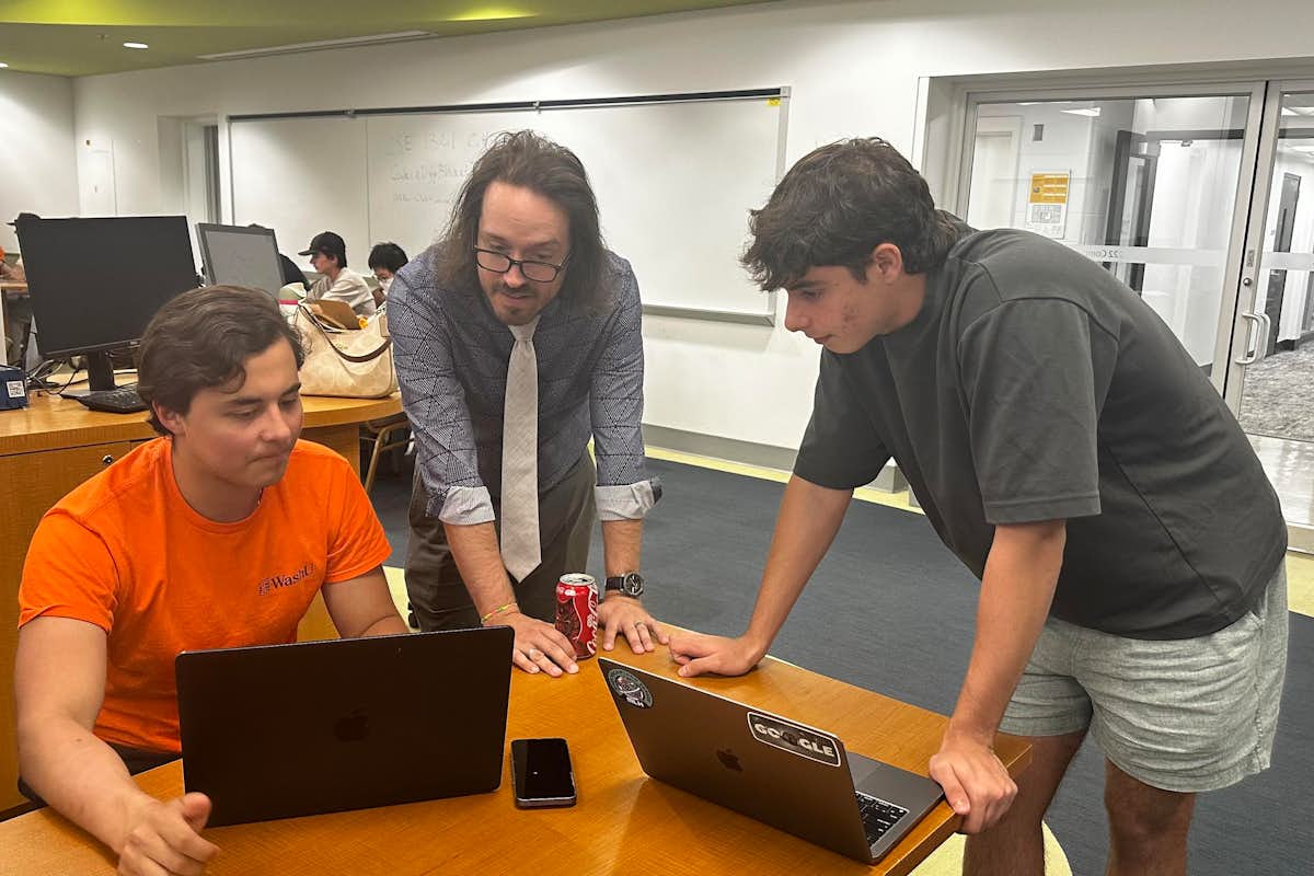 Doug Shook, teaching professor in computer science & engineering, works with students in a CSE1301 studio.
