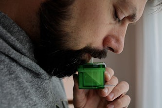 Benjamin Sumlin, a senior scientist at Washington University in St. Louis, blows into a device designed by researchers at the university. The device — a breath test that uses a biosensor — could become a tool for use in doctors’ offices to quickly diagnose people infected with the virus that causes COVID-19. (Chakrabarty lab)