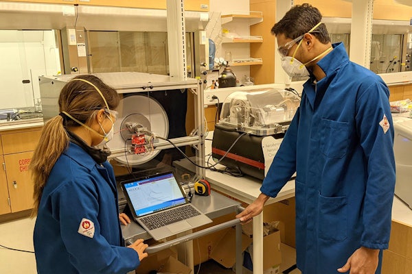 Graduate students Esther Monroe (left) and Nishit Shetty carry out droplet experiments using a custom-built environmental rotating chamber. A team of researchers at Washington University in St. Louis are developing devices to detect the virus that causes COVID-19 in the air.