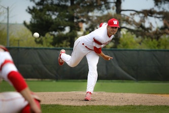 Loutos throws a warmup pitch during a game against Spalding University in April. (Photo by Clara Richards | Student Life)