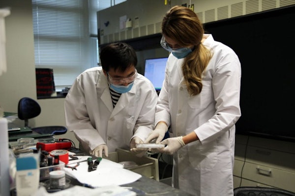 Brittany Daugs (right) and graduate student Jiang Luo conducted scientific research in the lab of Bryce Sadtler, assistant professor of chemistry in Arts & Sciences, last summer. For several years, university faculty have welcomed local teachers into their labs to participate in research and develop lesson plans. (Photo: Institute for School Partnership)